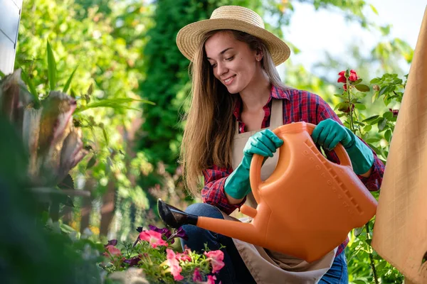Bahçesindeki Çiçekleri Sulamak Için Şapkalı Önlüklü Mutlu Bir Bahçıvan Kullanıyor — Stok fotoğraf