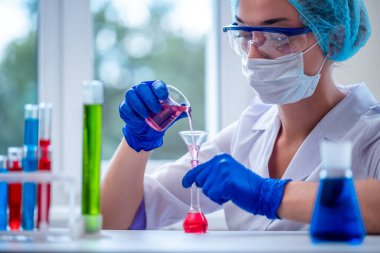 Klinik laboratuar araştırmaları, analizler ve testler için bilimsel cam eşyalar ve test tüpleri kullanan bir kadın kimyager. İlaç, eczane ve kozmetoloji kavramı. 