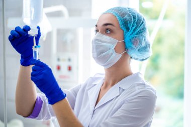 Revir üniformalı hemşire bir hastayı ameliyata hazırlıyor. 