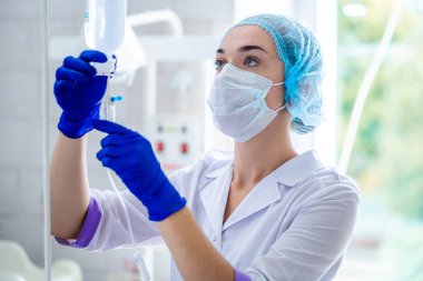 Revir üniformalı hemşire bir hastayı ameliyata hazırlıyor. 