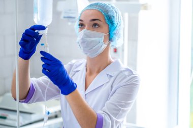 Revir üniformalı hemşire bir hastayı ameliyata hazırlıyor. 