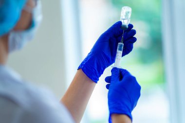 Salgın ve viral bulaşıcı hastalıklar sırasında insanların aşılanması. Hastanedeki bir hastaya antibiyotik enjekte etmek için şırınga kullanan hemşire.