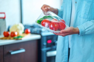 Kadın taze sebzeleri buzdolabında yiyecek depolamak için film olarak kullanmış.