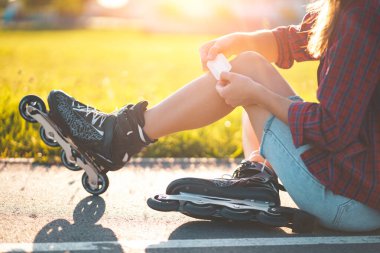 Paten kayarken dizinden yaralanan bir kadın. Bir genç paten yaparken düştükten sonra yara bandıyla yara bere içinde kalır. 