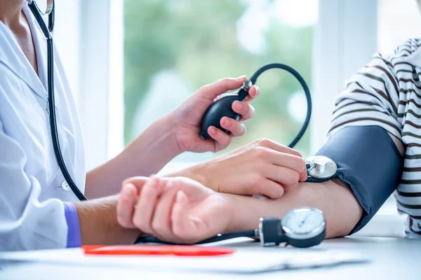 Doctor measures the blood pressure to patient during a medical examination and consultation in the hospital. Healthcare