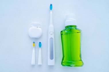 Beyaz arka planda ultrasonik diş fırçası ve diş hijyen ürünleri. 