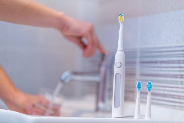 Ultrasonik elektrikli diş fırçası ve evdeki banyoda değiştirilebilir hortumlar. Ağız temizliği, diş ve diş sağlığı, sağlıklı dişler. Diş ürünleri 