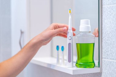 Ultrasonik elektrikli diş fırçası ile değiştirilebilir hortumlar ve banyoda temiz nefes almak için gargara. Ağız temizliği, diş ve diş sağlığı, sağlıklı dişler. Diş ürünleri 