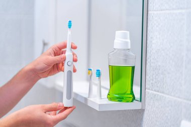 Ultrasonik elektrikli diş fırçası ile değiştirilebilir hortumlar ve banyoda temiz nefes almak için gargara. Ağız temizliği, diş ve diş sağlığı, sağlıklı dişler. Diş ürünleri 