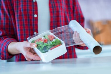Using food polyethylene plastic film for food storage in fridge at home 