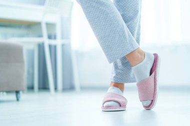 Female legs with cozy soft comfortable home slippers 