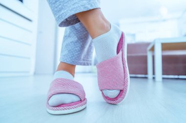 Female legs with cozy soft comfortable home slippers 