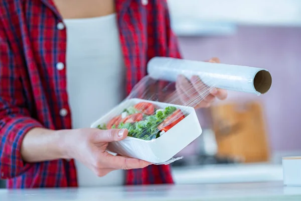 Käyttämällä Ruoka Polyeteeni Muovikalvo Elintarvikkeiden Säilytykseen Jääkaapissa Kotona — kuvapankkivalokuva