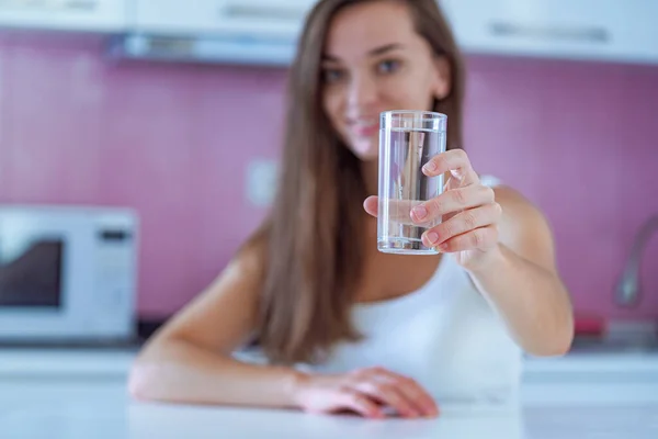 自宅のキッチンできれいな純水ガラスを手にした幸せな飲料女性 健康的なライフスタイル — ストック写真