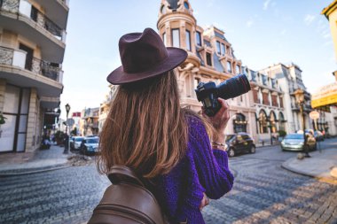 Havalı, modaya uygun hippi esmer kadın fotoğrafçı. Avrupa 'da dolaşırken kamera ve lens kullanarak fotoğraf çekiyor.