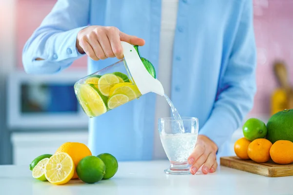 Kvinna Häller Uppfriskande Infunderad Avgiftning Citrusvatten Från Kanna Ett Glas — Stockfoto