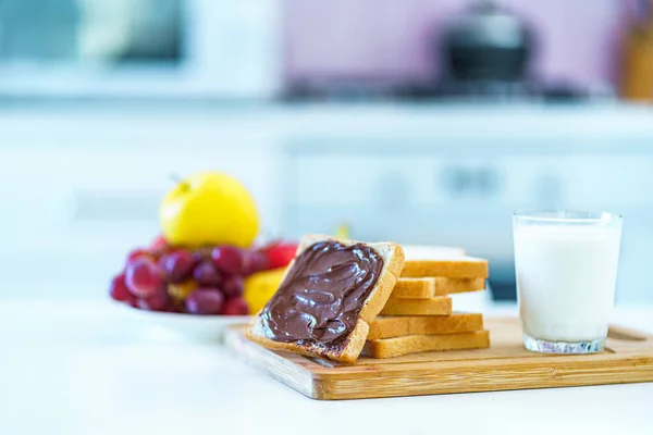 Smörgåsar Med Nötchoklad Smör Frukt Och Ett Glas Färsk Mjölk — Stockfoto