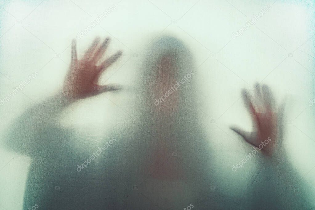 Shadow of scary paranormal ghost horror woman in soft focus. Blurry hand and body figure abstraction.