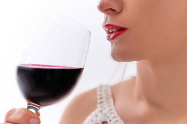 Bir bardak kuru kırmızı şarapla içen bir kadın.