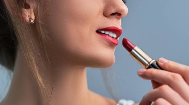 Parlak kırmızı ruju ve kırmızı dudakları olan zarif, güzel bir kadın modeli. Kozmetik ve makyaj 