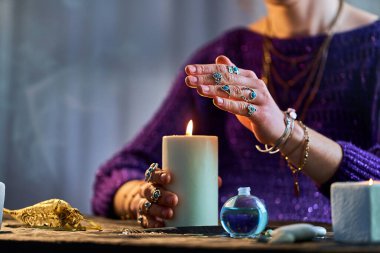 Falcı kadın cadılık, kehanet ve falcılık için yanan mum alevini kullanıyor. Ruhsal esrarengiz paranormal sihir gösterimi  