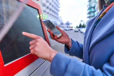 Hizmet ücreti olarak sokak self servis terminalini ve akıllı telefonu kullanan kişi. Dijital teknoloji yaşam tarzı