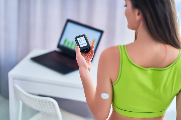 Woman diabetics control and checking glucose level with a remote sensor. Monitoring glucose levels without blood. Technology in sugar diabetes treatment and diabetic lifestyle