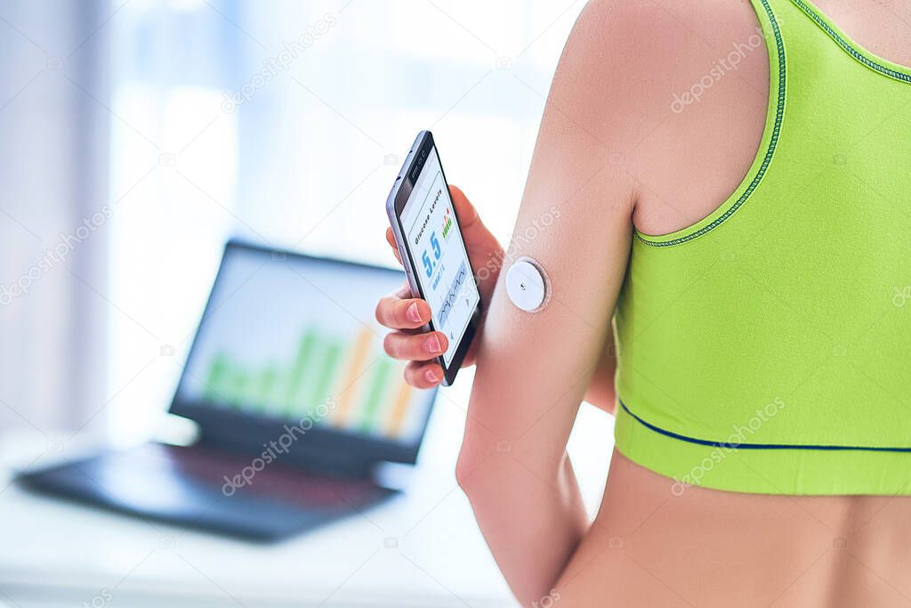 Woman diabetics control and checking glucose level with a remote sensor and mobile phone. Online monitoring glucose levels without blood using digital glucose meter. Technology in diabetes treatment