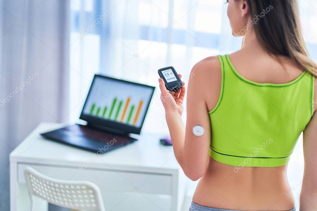 Woman diabetics control and checking glucose level with a remote sensor. Online continuous monitoring glucose levels without blood. Medical technology in diabetes treatment