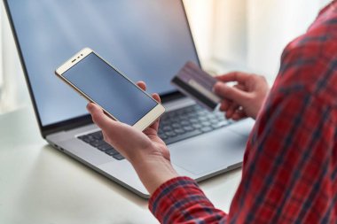 Kadınlar online alışveriş ve evde ödeme yapmak için dizüstü bilgisayar, plastik banka kartı ve akıllı telefon kullanıyor. E-ticaret ve mobil ödeme bankacılığı kullanan modern insanlar           