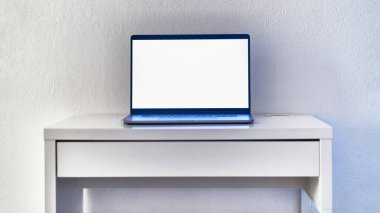 Beyaz bir iç mekânda çalışma masasında boş ekranı olan bilgisayar. Metin ve reklam için yer ve maket