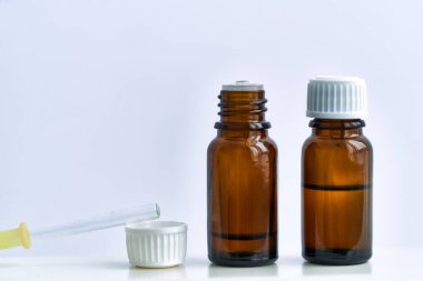 Aromaterapi, alternatif tıp ve cilt bakımı için doğal aroma yağı. Beyaz arka planda homeopati için bitkisel yağ şişeleri    