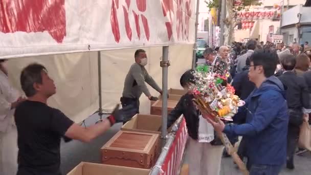 Vidéo de commerçants ramenant à Tori-no-Ichi Fair leurs râteaux de bon augure de l'année écoulée. — Video