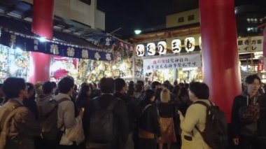 Tori-no-Ichi Fuarı sırasında Ootori Tapınağı 'nın torii kapısının altındaki kalabalığın videosu..