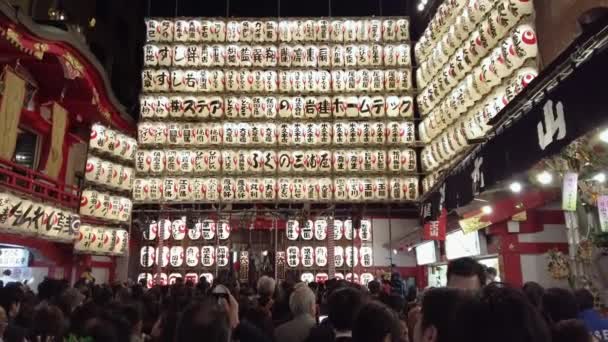 Tilt down video of crowd standing in line in Ootori shrine during the Tori-no-Ichi Fair. — Stock Video