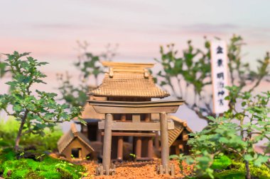 Shibuya, Japonya - Kasım 02 2020: Bonsai sanat ağaçları el yapımı minyatür bir kırsal alanda geleneksel kutsal bir Torii kapısının Japon tapınağının önünde resmedilmesi.