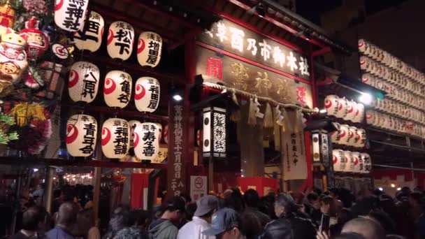 Crowd of faithful at the gate of the Tori-no-Ichi Fair at night. — Stock Video