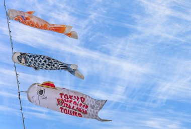 Tokyo, Japonya - Mayıs 05: 2021: Tokyo Kulesi 'ndeki Japon Koinobori ya da sazan desenlerine yakın çekim yapın ve Tokyo One Piece Tower eğlence parkının logosuyla süslenin..