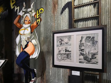 tokyo, japan - june 03 2021: Black and white comic strip of Japanese manga My Hero Academia aside a life sized standee of Rumi Usagiyama during exhibition drawing smash in Mori Arts Center Gallery. clipart