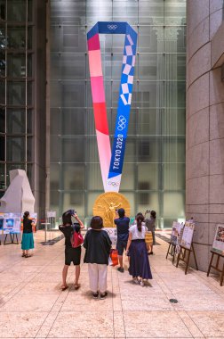 Tokyo, Japonya - 10 Ağustos 2021: Japonlar, Olimpiyat Agora sergisi için Nihonbashi Mitsui Kulesi 'nde düzenlenen 2020 Yaz Olimpiyatları' nda sergilenen altın madalyanın dev bir kopyasını çekiyorlar..