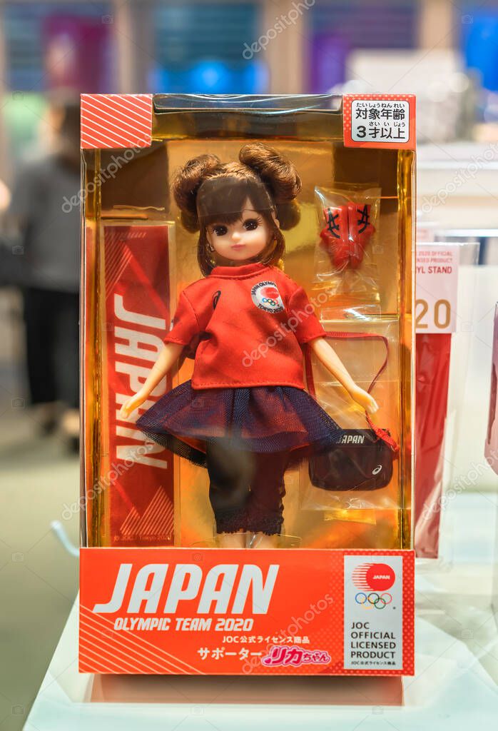 Tokyo japan - august 24 2021: Japanese Licca-chan doll dressed as a volunteer supporter with the 2020 japan olympic team official t-shirt decorated with the five rings emblem and asics shoes.