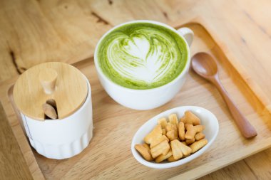 Beyaz fincan yeşil çay bir aperatif ile ahşap bir tepsi  