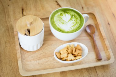 Beyaz fincan yeşil çay bir aperatif ile ahşap bir tepsi  