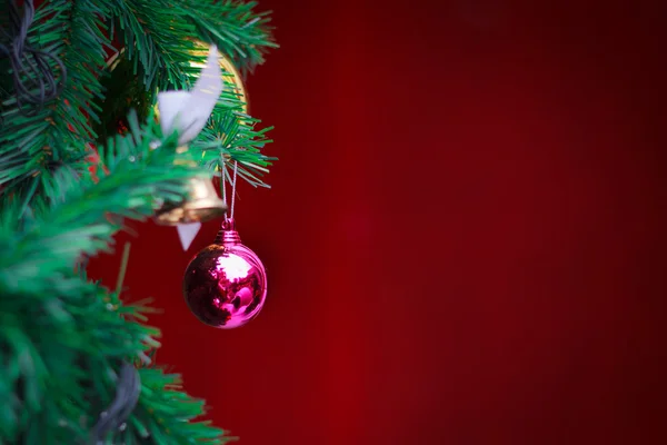 Närbild jul boll på röd bakgrund från julgran — Stockfoto