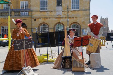 24 Nisan 2021 'de Stratford-upon-Avon' da flüt, arp ve davul çalan dönemin kostümlü üç müzisyeni.