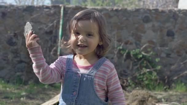 Kleines Mädchen wirft einen Stein auf den Fotografen — Stockvideo