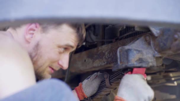 Homme répare une vieille voiture, change les amortisseurs, gros plan — Video
