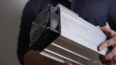 ASIC 'e madencilik için yakın plan Bitcoin, bir adamın elinde.