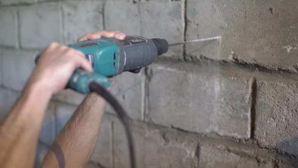 A puncher in the hands of a builder, a man inserts a drill into puncher — Stock Video