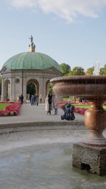 Serin bir bahçede renkli çiçeklerle çevrili nefes kesici bir köşk. Rahatlamak ve keyif almak için mükemmel. Yüksek kalite 4k görüntü